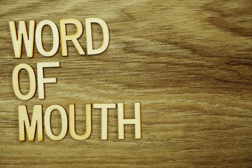 Word Of Mouth text message on wooden background