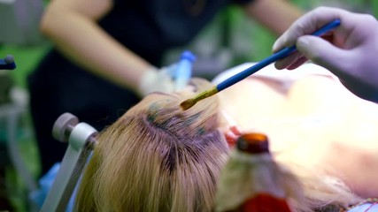 nurse is covering hair of female patient by disinfectant, medical personnel is preparing for craniotomy