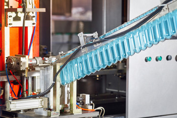 Modern automated production line in a factory. The process of making plastic bottles for water or...