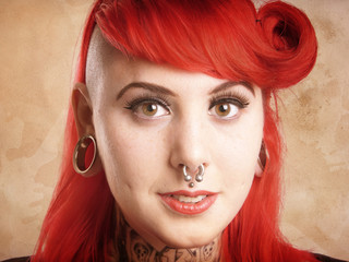 young alternative woman with side cut, facial piercings and tattoos - with added texture filter...