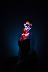 Girl's face painted UV skull