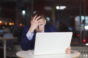 Businessman working at the table with a desk lamp.