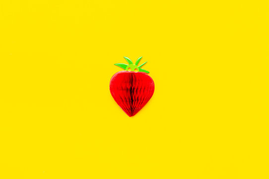 Flat lay bright sweet red strawberry of paper on yellow background top view copy space. Minimalistic creative summer food concept, origami paper fruit berry