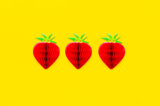 Flat lay bright sweet red strawberry of paper on yellow background top view copy space. Minimalistic creative summer food concept, origami paper fruit berry