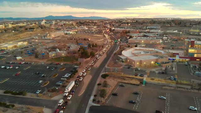 Aerial shot flying over traffic heading towards a big university. This was shot during the sunset as the sky was very colorful.