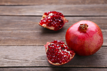 Pomegranate and half of ripe pomegranate on a grey background