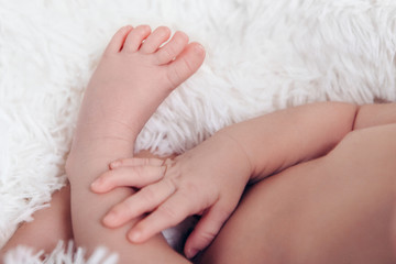 hand and leg of newborn baby close up on