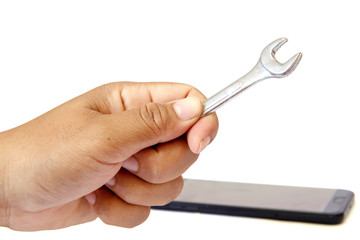 A Man's Hand Holding Wrench and black smartphone on white background. Repair concept Mobile phones.