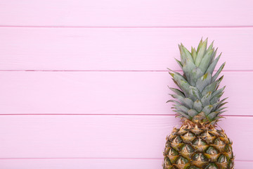 Ripe pineapple on a pink background with copy space