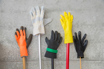 Fototapeta Handschuhe zur Reinigung lehnen auf Stielen an einer Betonwand obraz