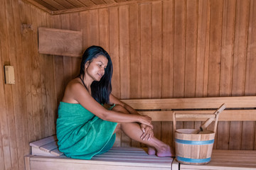 Asian woman in sauna relaxing during vacation