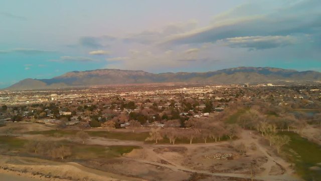 Aerial shot flying over a golf course towards the big city.