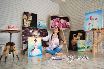  Art school student girl with her painting on exhibition show in a studio