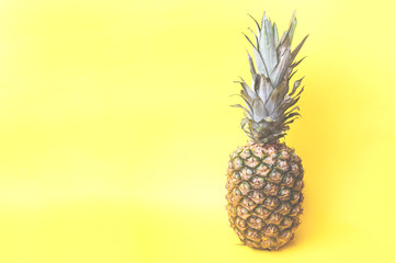 Ripe pineapple on a yellow toned background