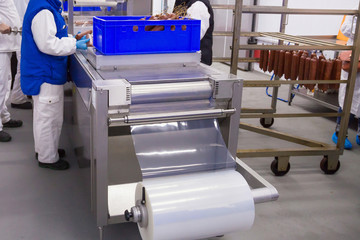 Process of the smoked sausages packaging in the meat plant.