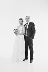 Wedding couple on the nature is hugging each other. Beautiful model girl in white dress. Man in suit. Beauty bride with groom. Female and male portrait. Woman with lace veil. Lady and guy outdoors