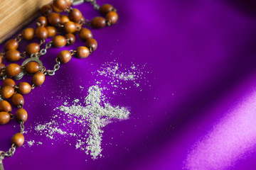 Ash Wednesday religion concept on violet fabric background with rosary 
