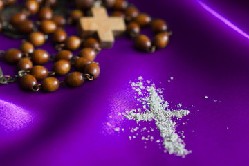 Ash Wednesday religion concept on violet fabric background with rosary 