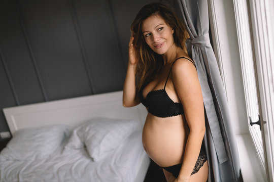 Fashion photo of beautiful pregnant girl posing in sexy black lingeri