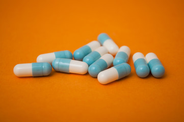 closeup of blue capsules on orange background