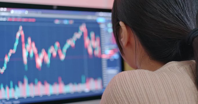 Woman check on stock market data at the screen of computer