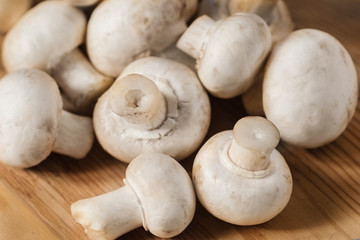 Tasty mushrooms on a wooden table. Mushrooms in the kitchen on a chopping board. Light background.