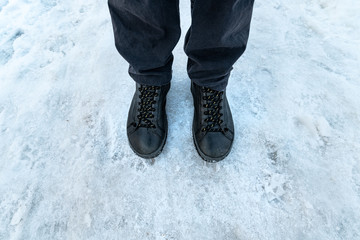 Male feet in boots standing in snow