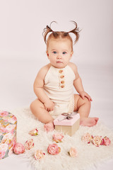 cute baby with flowers on a light background	