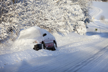Car driving in the ditch a very snowy day with a lot of snow