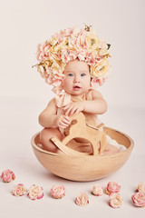 cute baby with flowers on a light background	