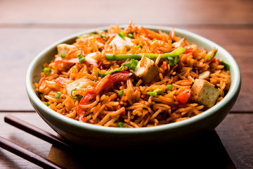 Schezwan paneer fried rice with Szechuan sauce and cottage cheese cubes. served in a bowl or plate or pan. selective focus