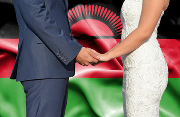 Fototapeta na wymiar Husband and Wife holding hands - Conceptual photograph of marriage in Malawi