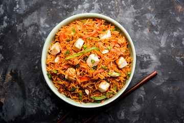 Schezwan paneer fried rice with Szechuan sauce and cottage cheese cubes. served in a bowl or plate or pan. selective focus