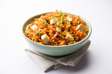 Schezwan paneer fried rice with Szechuan sauce and cottage cheese cubes. served in a bowl or plate or pan. selective focus