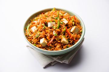 Schezwan paneer fried rice with Szechuan sauce and cottage cheese cubes. served in a bowl or plate or pan. selective focus