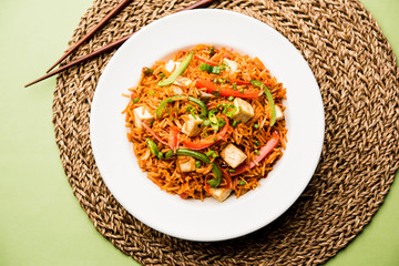 Schezwan paneer fried rice with Szechuan sauce and cottage cheese cubes. served in a bowl or plate or pan. selective focus