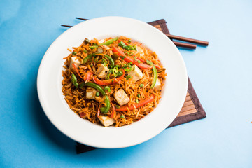 Schezwan paneer fried rice with Szechuan sauce and cottage cheese cubes. served in a bowl or plate or pan. selective focus