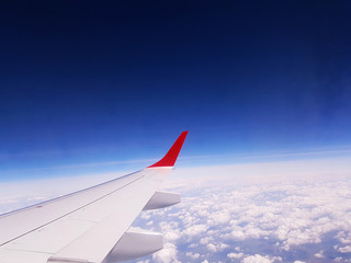 Fototapeta premium wing of an airplane flying above clouds