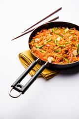 Schezwan paneer fried rice with Szechuan sauce and cottage cheese cubes. served in a bowl or plate or pan. selective focus