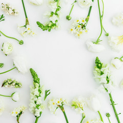 Floral frame of white flowers on white background. Flat lay, top view.