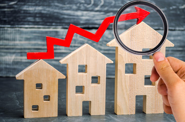 Wooden houses stand in a row from small to large with a red arrow up. concept of high demand for real estate. increase energy efficiency of housing. rise in house prices. property. population growth