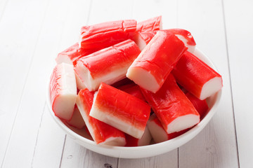 Salad crab sticks in a plate on a white table.