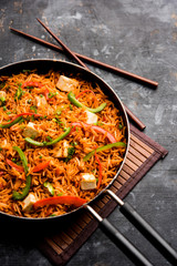 Schezwan paneer fried rice with Szechuan sauce and cottage cheese cubes. served in a bowl or plate or pan. selective focus