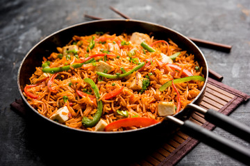 Schezwan paneer fried rice with Szechuan sauce and cottage cheese cubes. served in a bowl or plate...