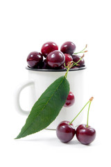 White cup with red sweet cherry isolated on a white background..