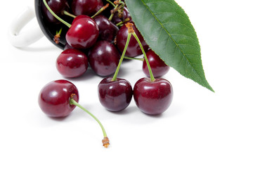 White cup with red sweet cherry isolated on a white background..