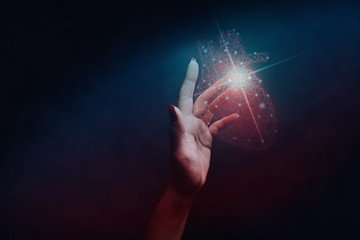 Human forefinger touches red heart innovative technologies. Nebula dust  in infinite space. Mixed...
