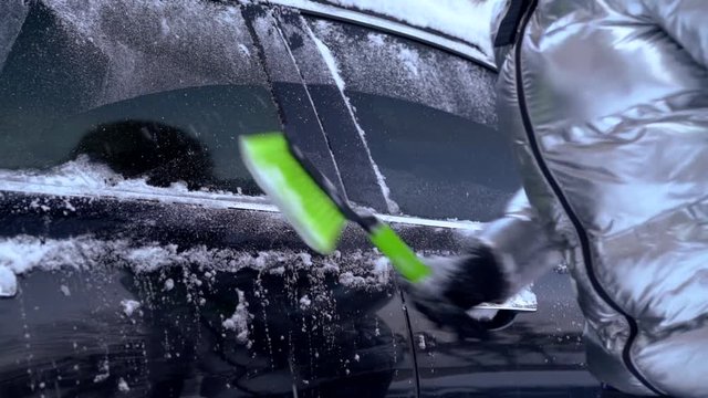 Cleaning car of snow after storm