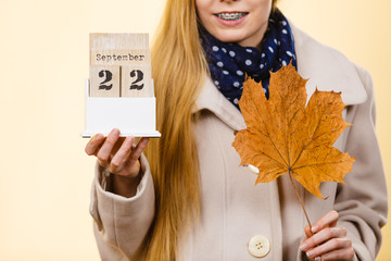 Woman holding calendar with first autumn day