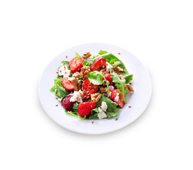 Salad with arugula, strawberries, goat cheese and walnuts isolated on white background with clipping path